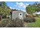 Lattice-covered outbuilding features a diamond-pane window, surrounded by lush plants at 4107 Dove Valley Ln, Lady Lake, FL 32159