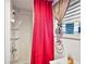 A shower unit is visible in this bathroom, with red curtains, and a window providing natural light at 4107 Dove Valley Ln, Lady Lake, FL 32159