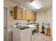 Functional laundry room with washer, dryer, sink and storage cabinets at 4818 Sawgrass Lake Cir, Leesburg, FL 34748