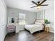 Bright bedroom featuring a vanity desk, a ceiling fan, and a bed with a decorative plant at 4857 Se 137Th Pl, Summerfield, FL 34491
