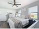 Bright bedroom featuring a ceiling fan, neutral walls, and a plush bed with a decorative throw at 4857 Se 137Th Pl, Summerfield, FL 34491