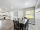 Open concept dining area with gray plank flooring, a modern table set, and natural light at 4857 Se 137Th Pl, Summerfield, FL 34491
