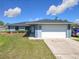 Charming home featuring a large two-car garage, well-maintained lawn, and manicured bushes at 4857 Se 137Th Pl, Summerfield, FL 34491