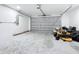 Spacious garage offering ample parking and storage space, with a mower and a gray door at 4857 Se 137Th Pl, Summerfield, FL 34491