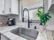 Close-up of a stainless steel kitchen sink with granite countertops and a matte black faucet at 4857 Se 137Th Pl, Summerfield, FL 34491