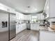 Modern kitchen featuring all white cabinetry, stainless steel appliances, and durable plank flooring at 4857 Se 137Th Pl, Summerfield, FL 34491