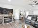Cozy living room features a fireplace, television and view into adjacent rooms at 4857 Se 137Th Pl, Summerfield, FL 34491