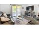 A living room with a fireplace, a large television and access to an enclosed patio at 4857 Se 137Th Pl, Summerfield, FL 34491