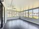 Bright sun room with expansive windows, ceiling fan, and durable plank flooring at 4857 Se 137Th Pl, Summerfield, FL 34491