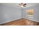 Bedroom featuring wood floors, a ceiling fan, and a large window at 502 Lake Gracie Dr, Eustis, FL 32726