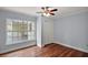 Bedroom features wood floors, a ceiling fan, and a large window at 502 Lake Gracie Dr, Eustis, FL 32726