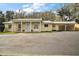 Home exterior features well-manicured lawn, charming front porch, and car port at 502 Lake Gracie Dr, Eustis, FL 32726