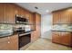 Well-equipped kitchen features wooden cabinetry, stainless steel appliances, and tiled backsplash at 502 Lake Gracie Dr, Eustis, FL 32726