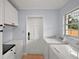 Bright laundry room features tiled floors, white cabinetry, and appliances, plus natural light from the window at 502 Lake Gracie Dr, Eustis, FL 32726