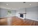 Spacious living room with hardwood floors and a charming brick fireplace at 502 Lake Gracie Dr, Eustis, FL 32726
