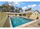 Large swimming pool with chairs and fenced-in backyard at 502 Lake Gracie Dr, Eustis, FL 32726