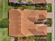 Overhead shot of a home with a red tile roof, showcasing the well-manicured landscaping and surrounding greenery at 5056 Harbour Dr, Oxford, FL 34484