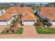 Stunning aerial view of a home with a tile roof, brick driveway, and beautifully landscaped yard at 5056 Harbour Dr, Oxford, FL 34484