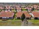 Aerial view of a residential neighborhood featuring well-maintained homes with red tile roofs and green lawns at 5056 Harbour Dr, Oxford, FL 34484