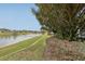 Scenic backyard view with a lush green lawn and a serene lake featuring a fountain at 5056 Harbour Dr, Oxford, FL 34484