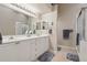 Well-lit bathroom featuring double sinks, white cabinets and walk-in shower at 5056 Harbour Dr, Oxford, FL 34484