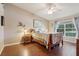 Bedroom featuring hardwood floors, large windows, and a decorative floral painting at 5056 Harbour Dr, Oxford, FL 34484