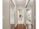 Hallway featuring hardwood floors and doors to bathrooms with mirrored closets at 5056 Harbour Dr, Oxford, FL 34484
