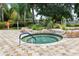 A hot tub is surrounded by natural stone, landscaping and features a metal railing at 5056 Harbour Dr, Oxford, FL 34484