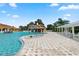 A large pool features a rock waterfall, with abundant patio seating and palm trees at 5056 Harbour Dr, Oxford, FL 34484
