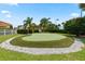 A putting green is surrounded by well kept landscaping and green space at 5056 Harbour Dr, Oxford, FL 34484