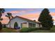 A home's rear exterior shows a screen porch, landscaping, and chairs to sit and enjoy the backyard at 5056 Harbour Dr, Oxford, FL 34484