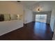 Living room with sliding doors, dark wood floors and view into the kitchen at 5214 Via Hacienda Cir # A308, Orlando, FL 32839