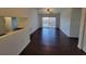 Open living room with dark wood floors, view into the kitchen, ceiling fan, and sliding door to the balcony at 5214 Via Hacienda Cir # A308, Orlando, FL 32839