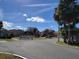 Street view showcasing a well-maintained community with mature trees and blue skies with scattered clouds at 5214 Via Hacienda Cir # A308, Orlando, FL 32839