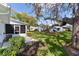 Backyard view with grass, shrubs, and a large tree; showcasing the property's serene outdoor space at 5402 Rosewall Cir, Leesburg, FL 34748