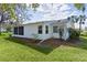 Back exterior view of a white home with green lawn, trees, and a screened lanai at 5402 Rosewall Cir, Leesburg, FL 34748