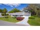 Charming single-story home with lush landscaping, paved driveway and attached garage at 5402 Rosewall Cir, Leesburg, FL 34748