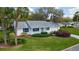 Charming single-story home with manicured lawn and lush landscaping, including mature trees and colorful bushes at 5402 Rosewall Cir, Leesburg, FL 34748