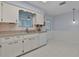 Traditional kitchen with a white dishwasher, cabinets, sink, and a light hanging from the ceiling at 5402 Rosewall Cir, Leesburg, FL 34748