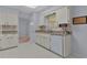 Bright kitchen featuring white cabinets, tile floors, and a neutral-toned countertop at 5402 Rosewall Cir, Leesburg, FL 34748