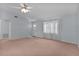 Open living room with neutral walls, carpeted floor, and natural light at 5402 Rosewall Cir, Leesburg, FL 34748