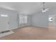 A cozy living room with neutral walls, carpeted floors, and natural light from a large window at 5402 Rosewall Cir, Leesburg, FL 34748