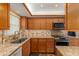 Modern kitchen featuring stainless steel appliances, granite countertops, and wood cabinets at 601 N Mcdonald St # 208, Mount Dora, FL 32757
