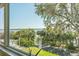 Scenic exterior view with lush trees, cars parked, blue skies, and water at 601 N Mcdonald St # 208, Mount Dora, FL 32757