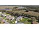 Aerial view of a lovely single-story home with a long driveway, lush green lawn, and beautiful lake views at 6022 Wilander St, Leesburg, FL 34748