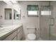 Bathroom with walk-in shower, toilet, sink and vanity with mirror and tiled flooring at 6022 Wilander St, Leesburg, FL 34748