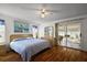 Comfortable bedroom featuring wood floors, a ceiling fan, and sliding door access to the sunroom at 6022 Wilander St, Leesburg, FL 34748