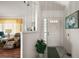 Bright foyer with a plant, painting and lots of natural light shining through the glass front door at 6022 Wilander St, Leesburg, FL 34748