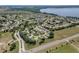 Aerial view showcasing a community with mature trees, a lake, and athletic fields at 6122 Sailboat Ave, Tavares, FL 32778