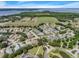 Aerial view of a residential neighborhood and surrounding areas with lakes, fields, and mature trees at 6122 Sailboat Ave, Tavares, FL 32778